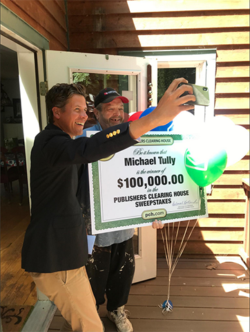 Michael T., winner of PCH Keno $100,000.00 prize, and Prize Patrol member Howie.